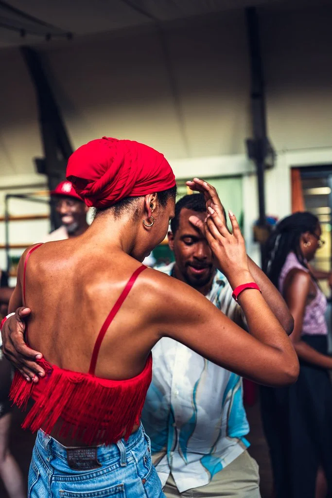Danseres met rode hoofddoek dicht tegen haar danspartner
