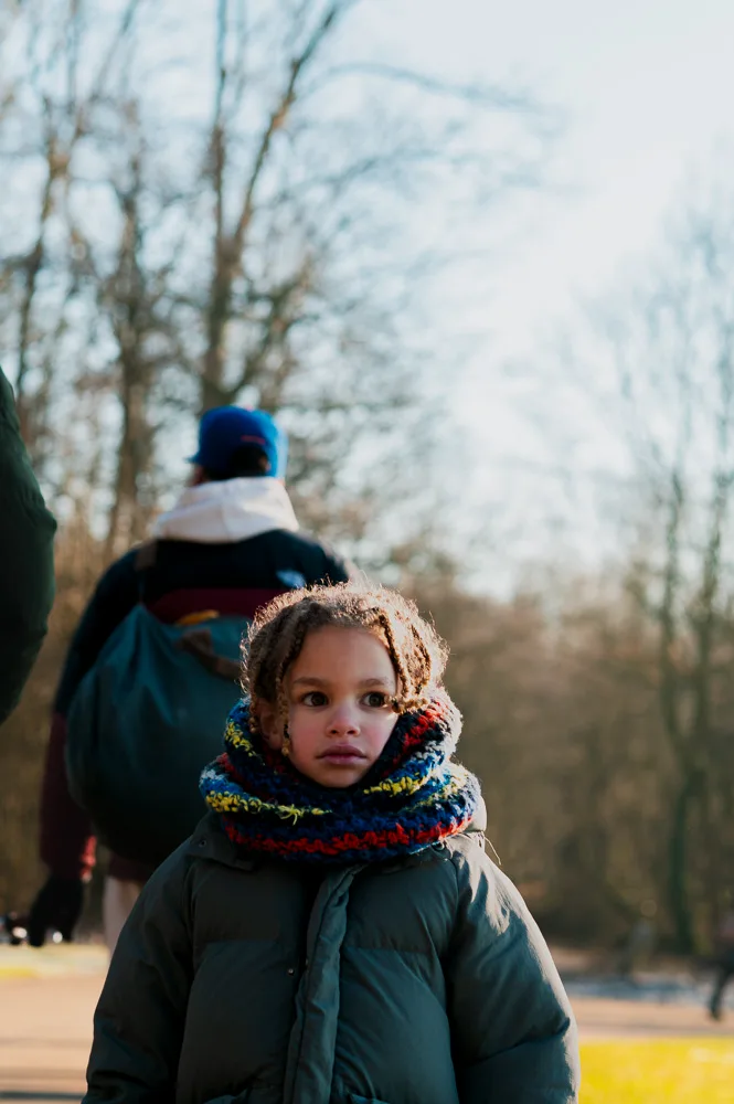 Kind met een dikke gebreide sjaal loopt mee met de wandelgroep