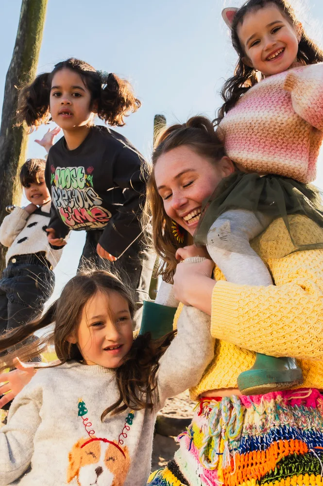 Romy met kinderen van de wandelgroep op haar schouders en aan haar hand